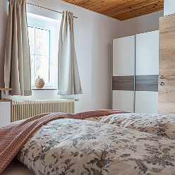 Ein Schlafzimmer in der Grundlwald Ferienwohnung Lorbeer